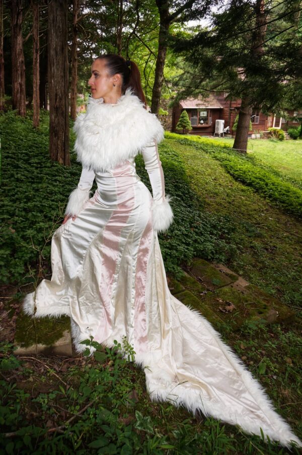 Woman modeling an Elegant Champagne, Cream Evening Gown with Train and Faux Fur in outdoor setting