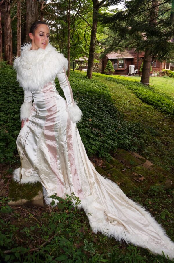 Woman modeling an Elegant Champagne, Cream Evening Gown with Train and Faux Fur in outdoor setting